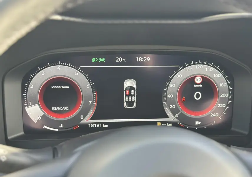 Tableau de bord digital du Nissan Juke 2025, affichant compte-tours, vitesse à zéro et alertes de porte ouverte.