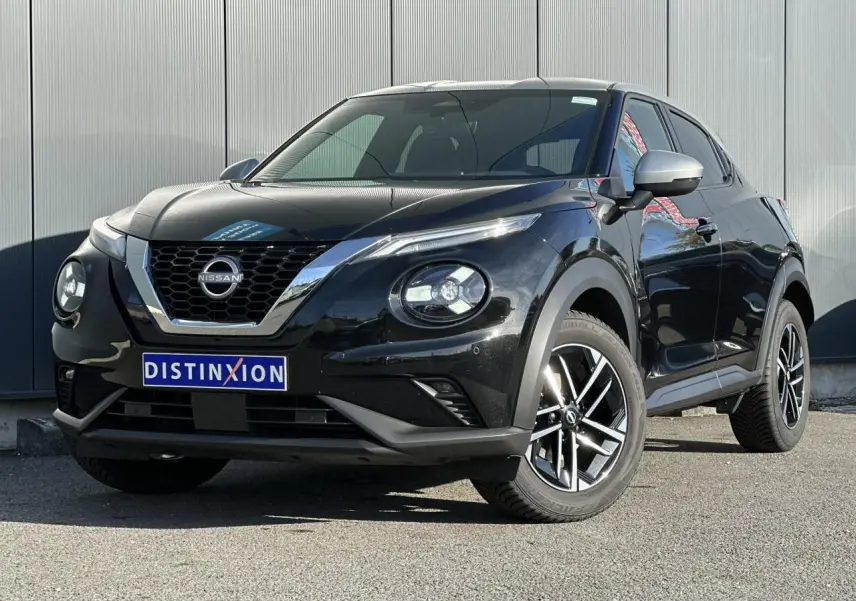 Nissan Juke noir en 3/4 avant droit, avec jantes alliage et calandre chromée brillante.