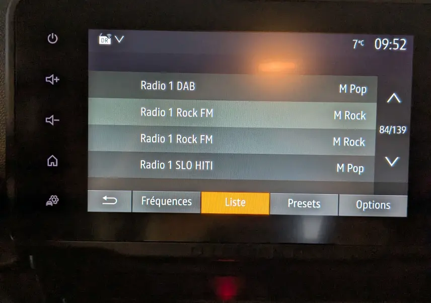 Écran tactile central du Dacia Duster 2023 affichant la liste des radios DAB avec options de menu en bas.