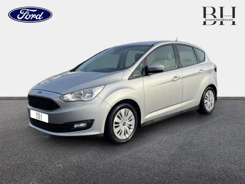 Ford C-MAX gris lunaire en vue 3/4 avant droit, mettant en valeur sa calandre noire et ses jantes à enjoliveurs.