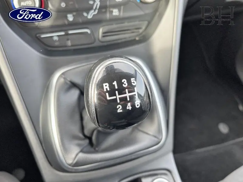 Gros plan sur le levier de vitesses manuel noir du Ford C-MAX gris lunaire, montrant les six rapports et la marche arrière.