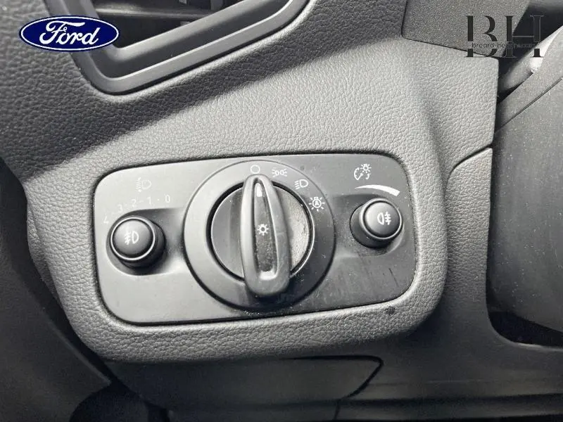 Gros plan sur le panneau de commande des phares noir à gauche du volant dans un Ford C-MAX gris lunaire 2018.