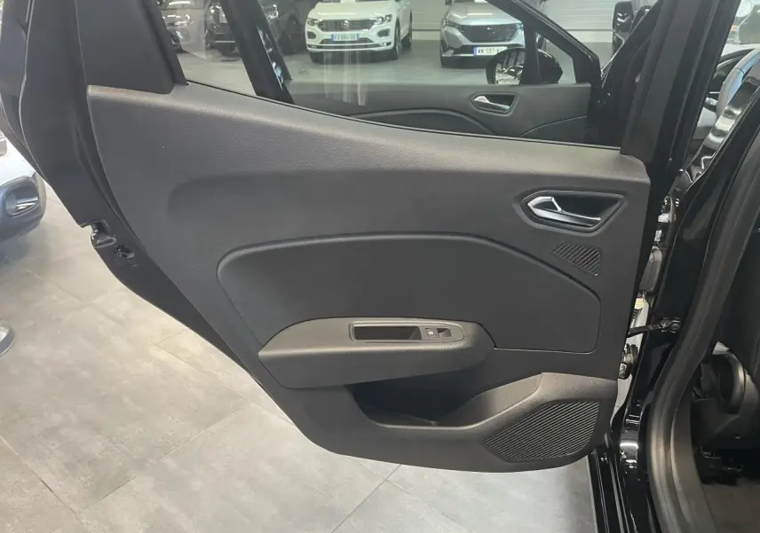 Porte arrière gauche ouverte de Renault Clio noire étoile, montrant la garniture intérieure sobre avec commande de vitre.