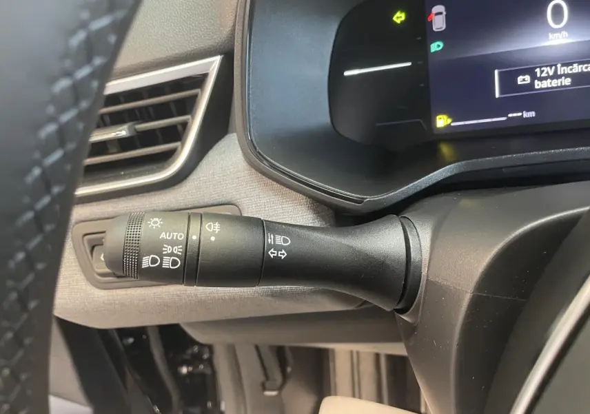 Gros plan sur la commande des phares et clignotants côté gauche du tableau de bord de la Renault Clio noire étoile 2025.