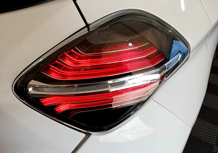 Gros plan sur le feu arrière droit rouge et blanc d'une Renault ZOE blanche, version Zen R110 de 2019.