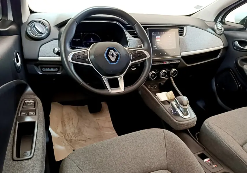 Vue intérieure avant de la Renault ZOE Zen R110, tableau de bord avec écran tactile et volant multifonctions en cuir synthétique.