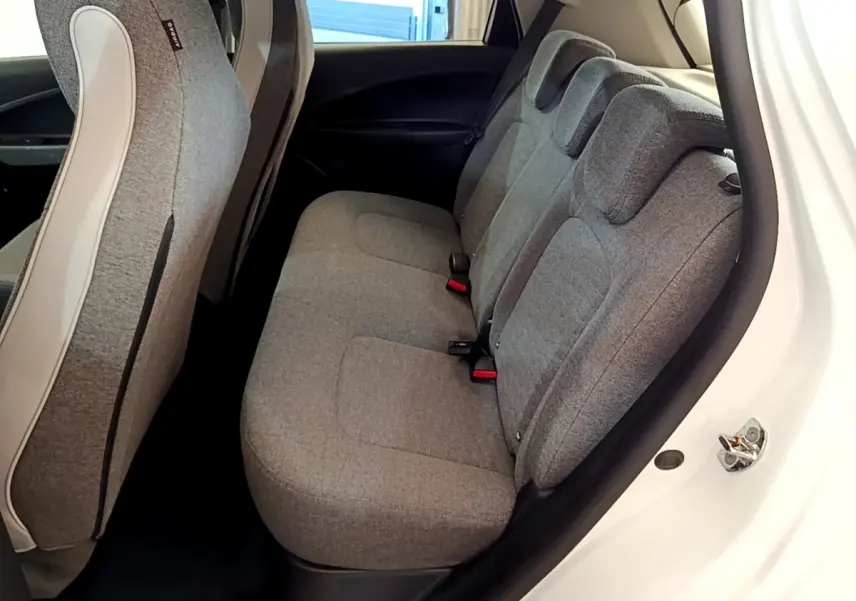 Vue intérieure côté droit sur la banquette arrière grise de la Renault ZOE Zen R110 blanche, avec sièges 3 places et appuie-têtes.