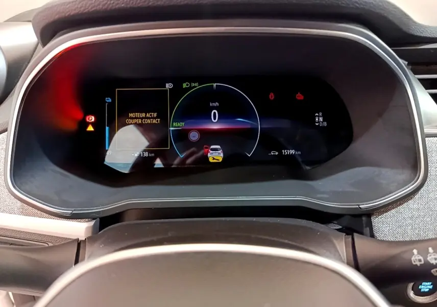 Vue rapprochée du combiné d'instruments numérique de la Renault ZOE blanche, affichant 0 km/h et alertes actives.