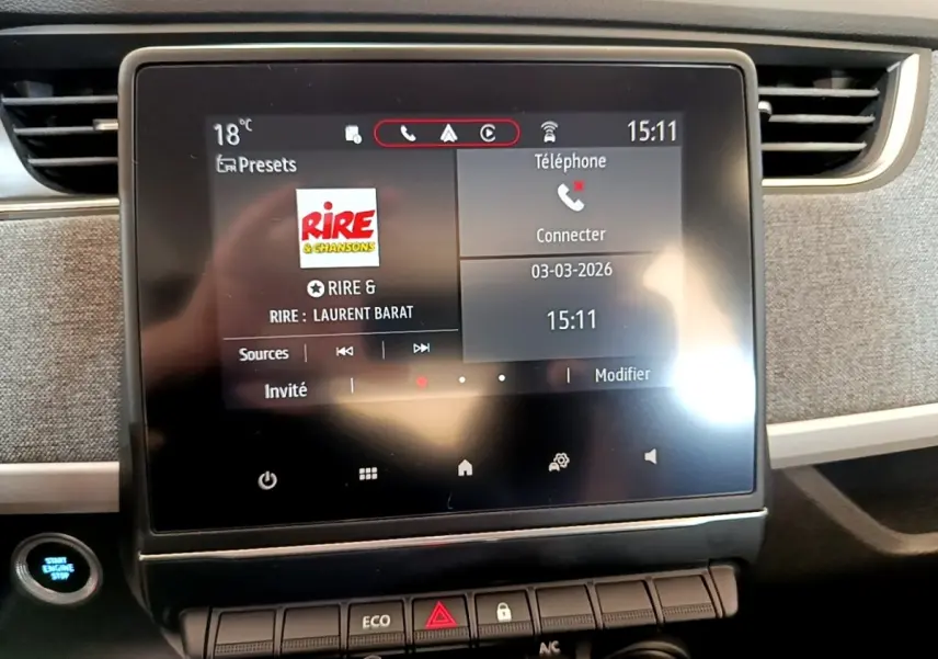 Écran tactile central de la Renault ZOE Zen R110 blanc, affichant la radio et les options téléphone, avec bouton démarrage visible.