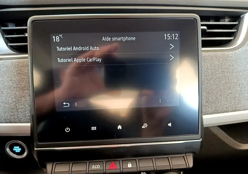 Écran tactile central de la Renault ZOE Zen R110 blanc, affichant tutoriels Android Auto et Apple CarPlay.