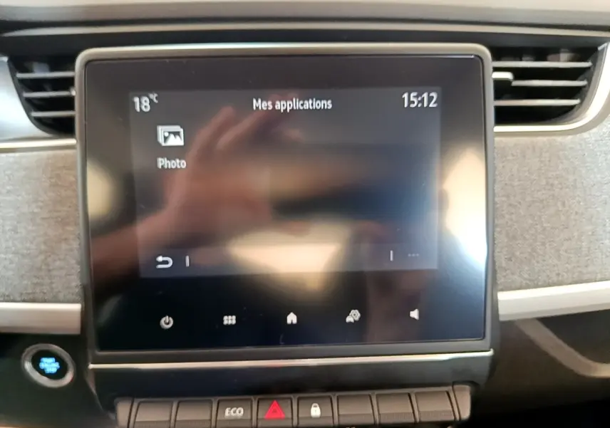 Écran tactile central de la Renault ZOE Zen R110 blanc, vue frontale du tableau de bord avec commandes et bouton démarrage.