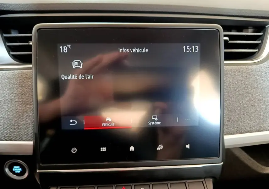 Écran tactile central de la Renault ZOE blanche 2019 affichant les infos véhicule et la qualité de l'air.