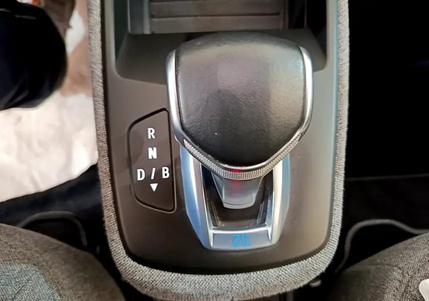 Le levier de vitesse noir et argenté de la Renault ZOE blanche, vue en gros plan sur la console centrale.