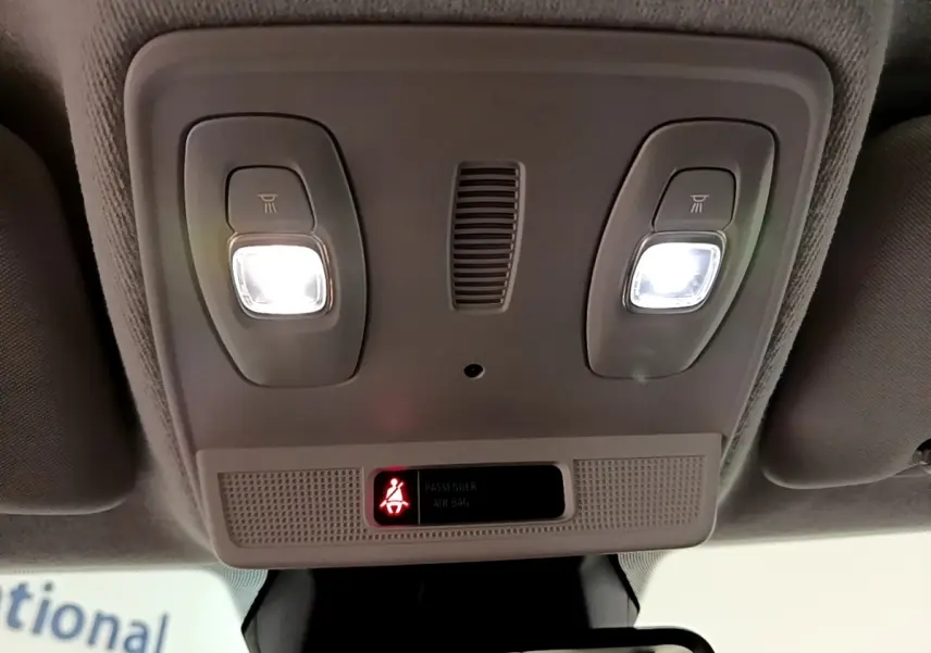 Vue intérieure du plafonnier avec éclairages allumés et témoin de ceinture passager sur une Renault ZOE blanche.