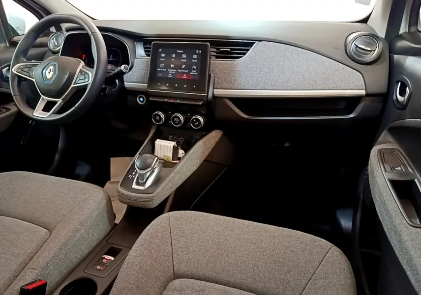 Vue intérieure avant de la Renault ZOE Zen R110, sièges et tableau de bord gris avec écran tactile central.