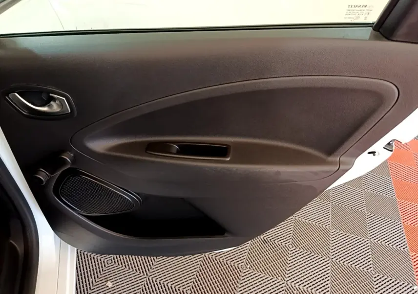 Vue rapprochée de la porte arrière droite blanche d'une Renault ZOE Zen R110 avec panneau intérieur noir et haut-parleur intégré.