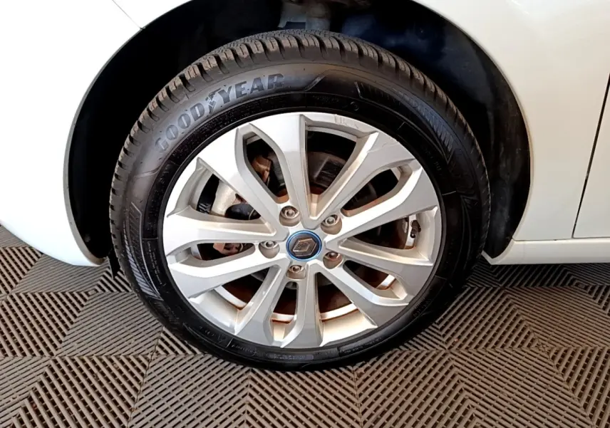 Gros plan sur la roue avant droite blanche d'une Renault ZOE 2019 avec jante alliage et logo Renault au centre.