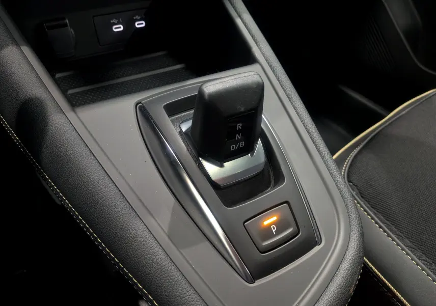 Le levier de vitesses automatique noir de la Renault Symbioz E-Tech, avec bouton de parking éclairé, vue intérieure rapprochée.