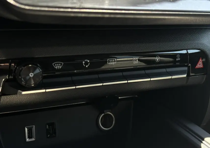 Détail de la console centrale noire du Citroën C5 Aircross Hybrid 2025 avec boutons de commande et prises USB visibles.
