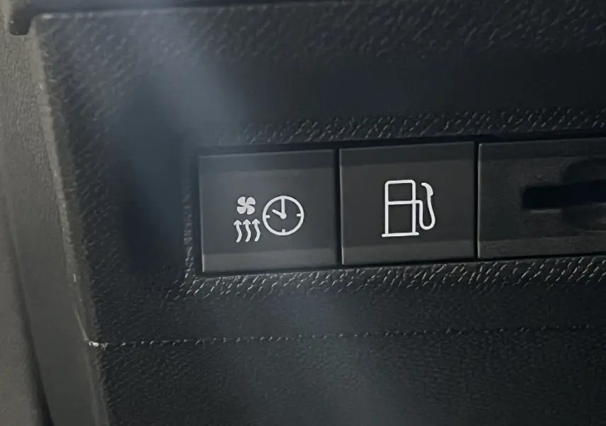 Gros plan sur les boutons de commande intérieurs du Peugeot 308 GT PHEV blanc nacré, avec symbole chauffage et carburant.