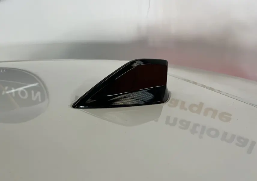Antenne requin noire sur toit blanc nacré d'une Peugeot 308 GT PHEV 2022, vue rapprochée en plongée.
