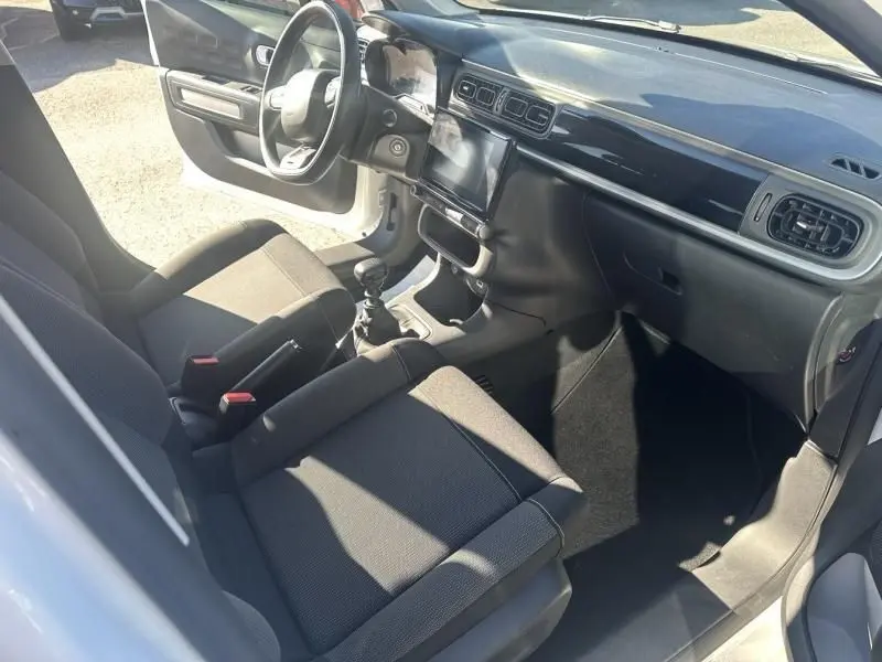 Intérieur avant droit de la Citroën C3 1.2 PureTech 110 Feel Pack 2021 avec tableau de bord noir et sièges gris.