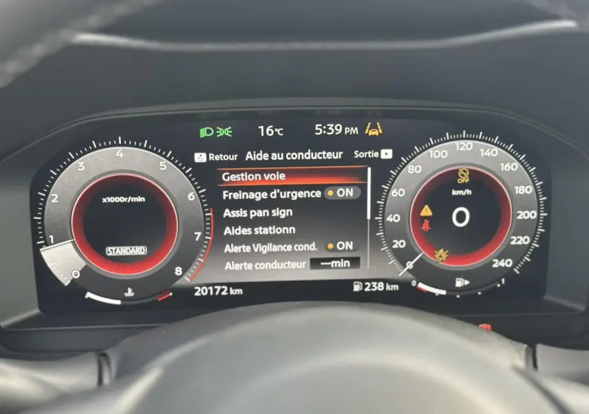 Tableau de bord digital du Nissan Juke 2025 affichant l'aide au conducteur et compte-tours en vue frontale.