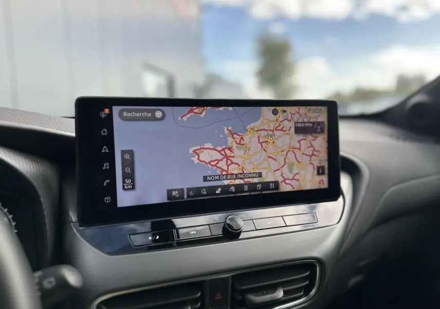 Écran tactile central affichant la navigation GPS dans l'habitacle du Nissan Juke blanc nacré 2025.