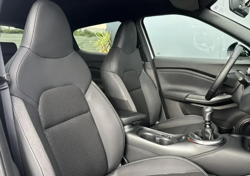 Vue intérieure côté droit du Nissan Juke 2025 N-Connecta, sièges noirs et levier de vitesse manuel visibles.