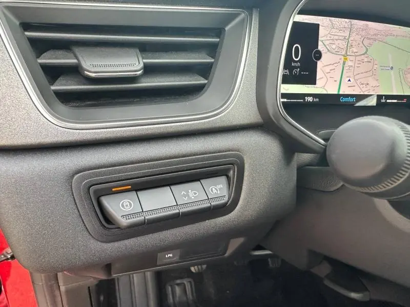 Détail intérieur côté gauche du tableau de bord du Renault Captur 2025 Rouge Flamme/Noir Etoilé avec commandes et écran digital.