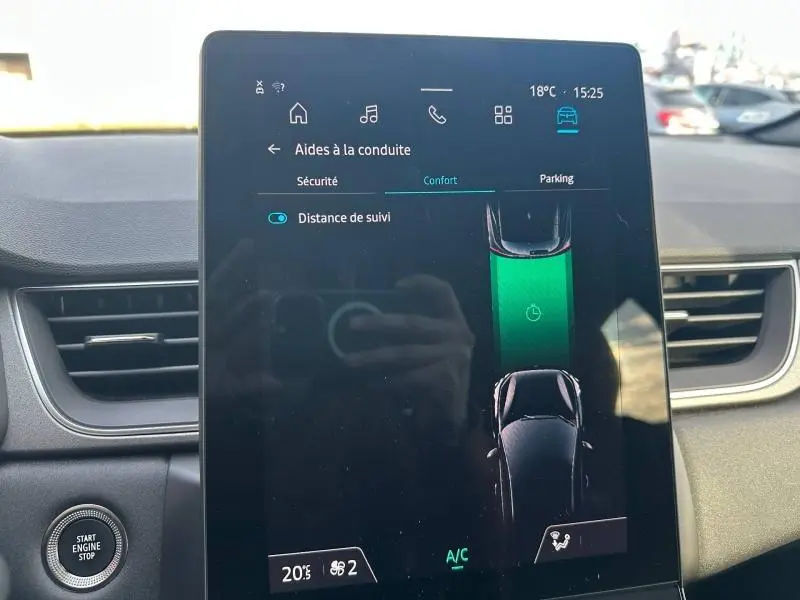 Écran tactile central du Renault Captur 2025 affichant les aides à la conduite, avec tableau de bord noir en arrière-plan.