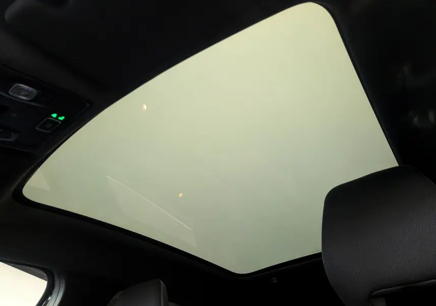 Toit panoramique en verre vu de l'intérieur d'un Renault Symbioz noir étoilé, ambiance intérieure sombre.