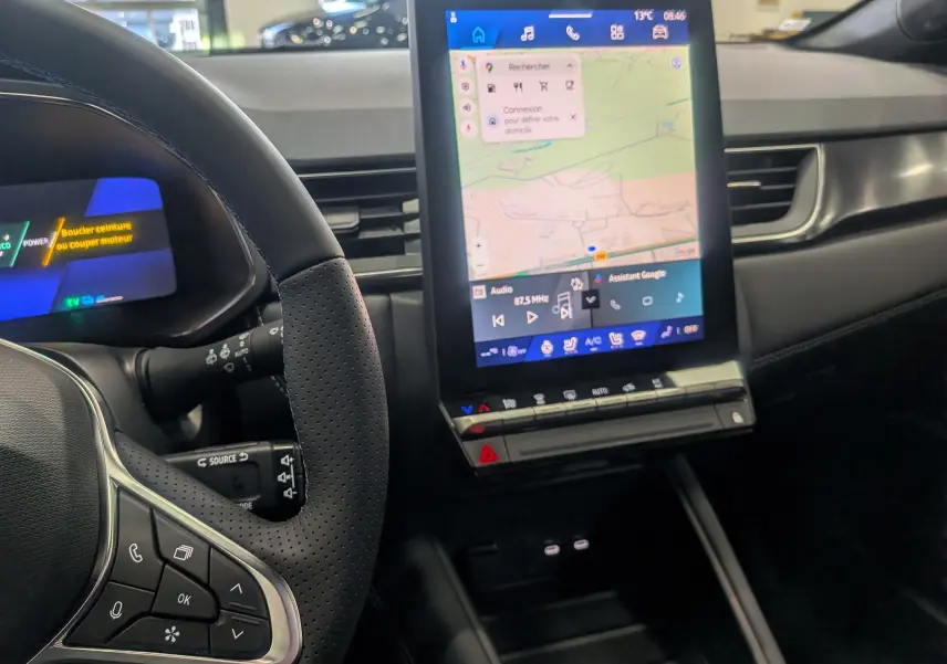 Vue intérieure centrée sur le volant et l’écran tactile vertical du tableau de bord du Renault Symbioz noir étoilé.