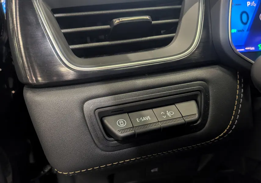 Gros plan sur les commandes E-SAVE et réglage des phares dans l’habitacle noir étoilé du Renault Symbioz 2026.