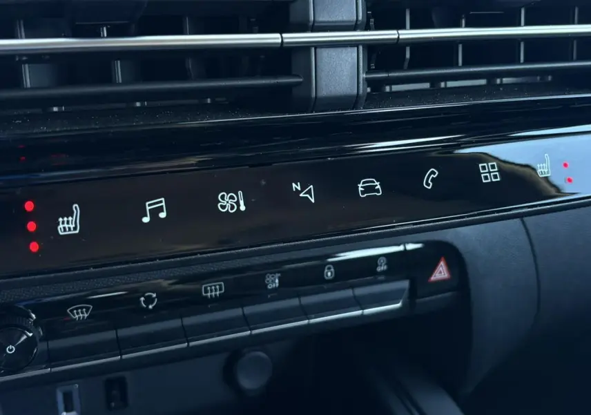 Détail du tableau de bord noir du Citroën C5 Aircross Hybrid 2025 avec commandes tactiles et voyants rouges allumés.