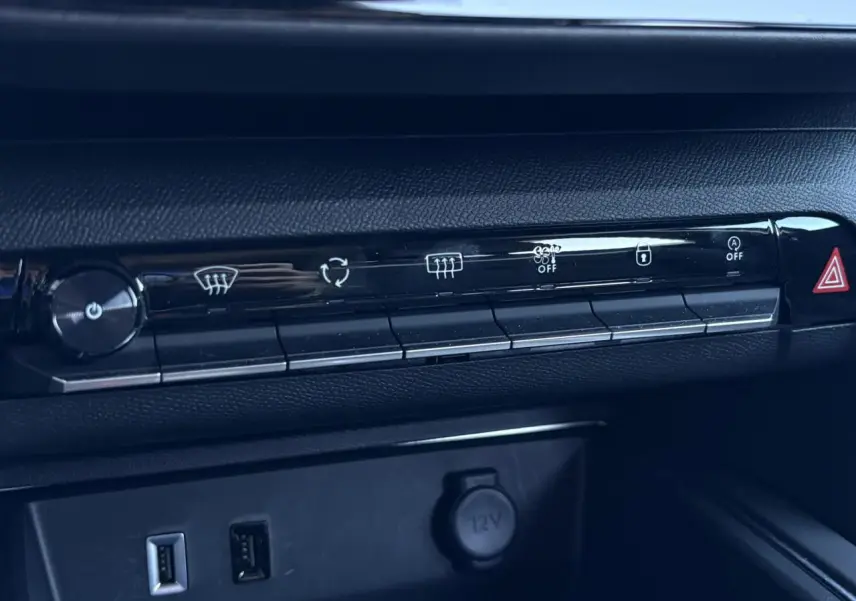Gros plan sur la console centrale noire du Citroën C5 Aircross Hybrid avec commandes climatisation et prises USB visibles.