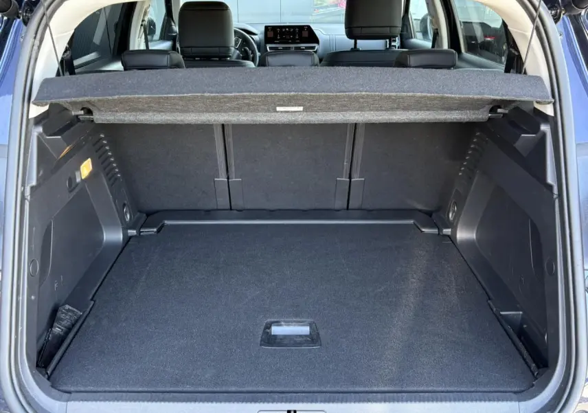 Vue arrière du coffre ouvert du Citroën C5 Aircross Hybrid bleu Eclipse, montrant l'espace de chargement et la plage arrière.