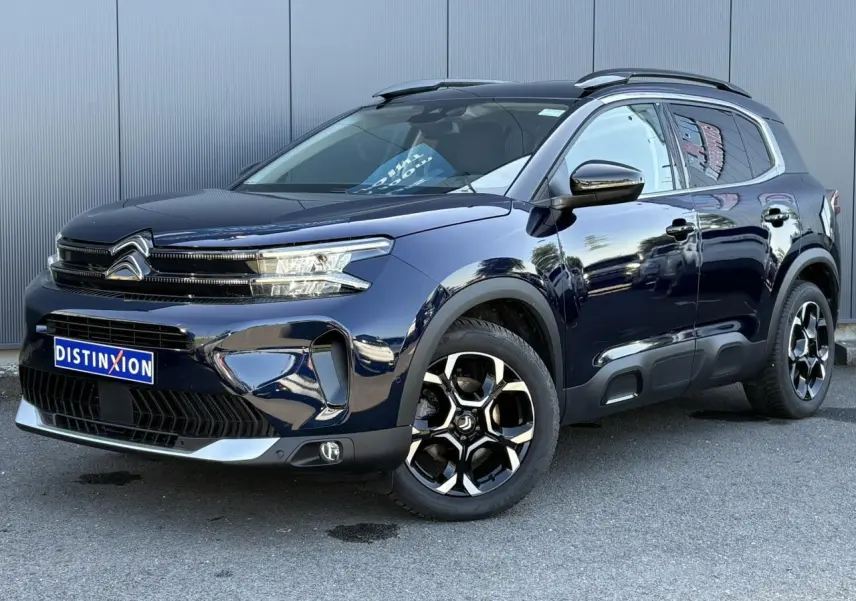 Vue 3/4 avant droite du Citroën C5 Aircross Hybrid bleu Eclipse avec jantes alliage bi-ton et barres de toit noires.