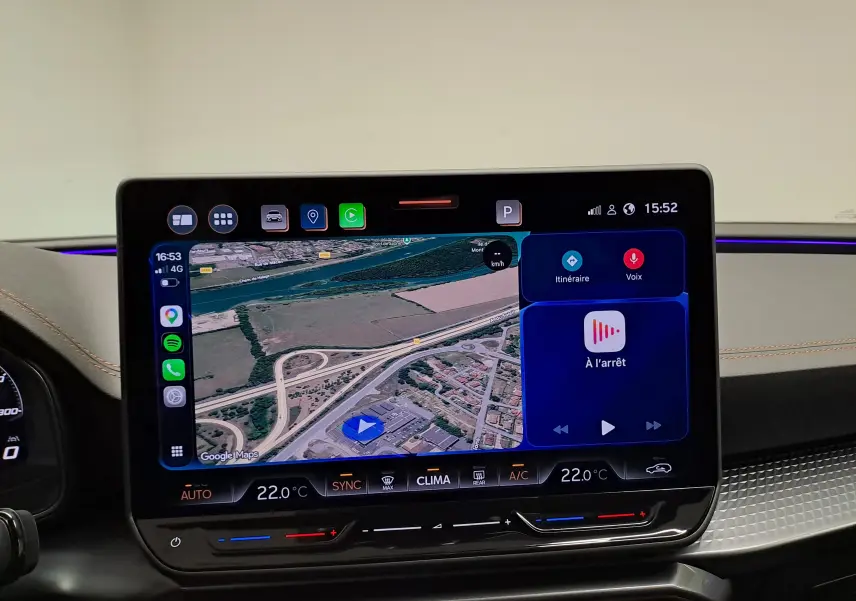 Vue intérieure centrée sur l’écran tactile du tableau de bord du CUPRA Leon 2025 avec navigation et commandes climatiques.