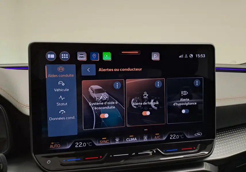 Écran tactile central du tableau de bord de la CUPRA Leon 2025 affichant les alertes au conducteur et la climatisation.
