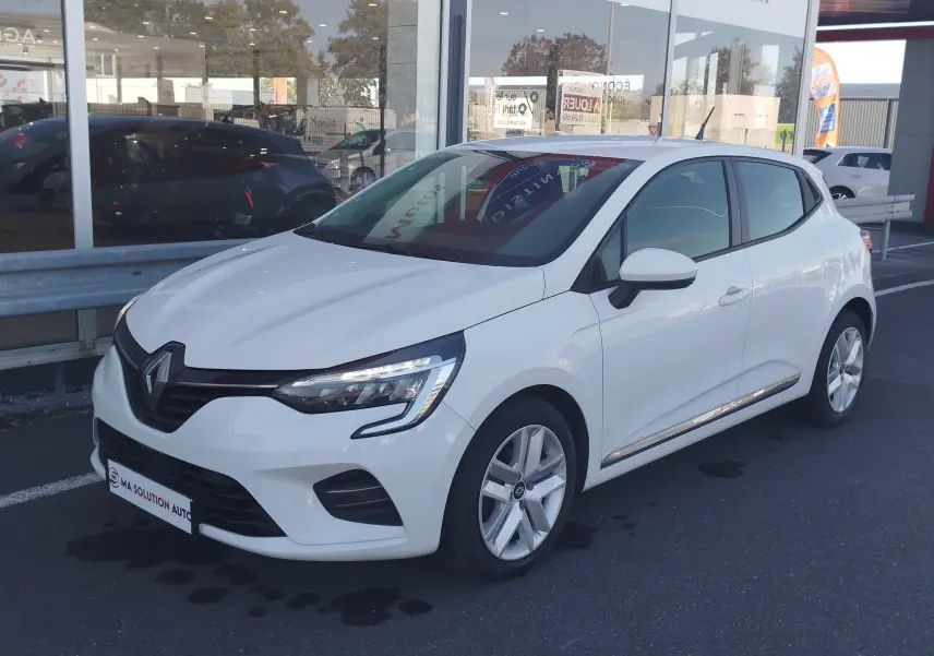 Renault Clio Business blanche vue 3/4 avant droit, avec feux LED et jantes alliage visibles, stationnée devant un showroom.