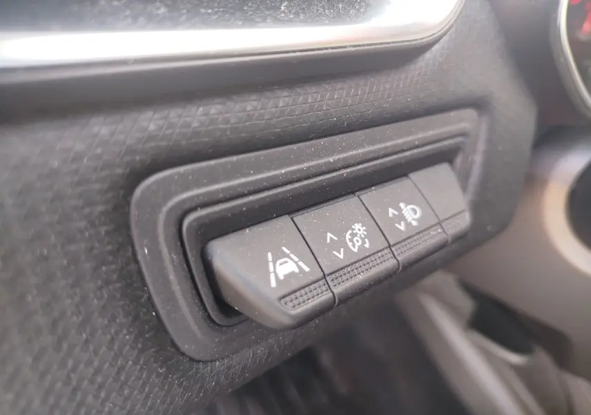 Gros plan sur les boutons de réglage d'assistance à la conduite et d'éclairage dans l'habitacle d'une Renault Clio blanche 2021.