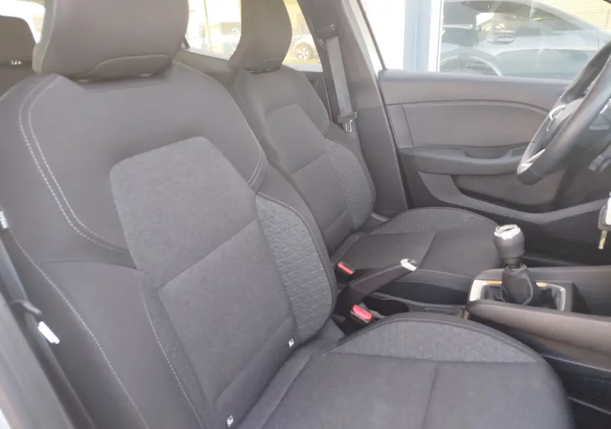 Vue intérieure côté conducteur de la Renault Clio Business 2021, sièges tissu gris foncé avec coutures contrastées et levier de vitesse manuel.