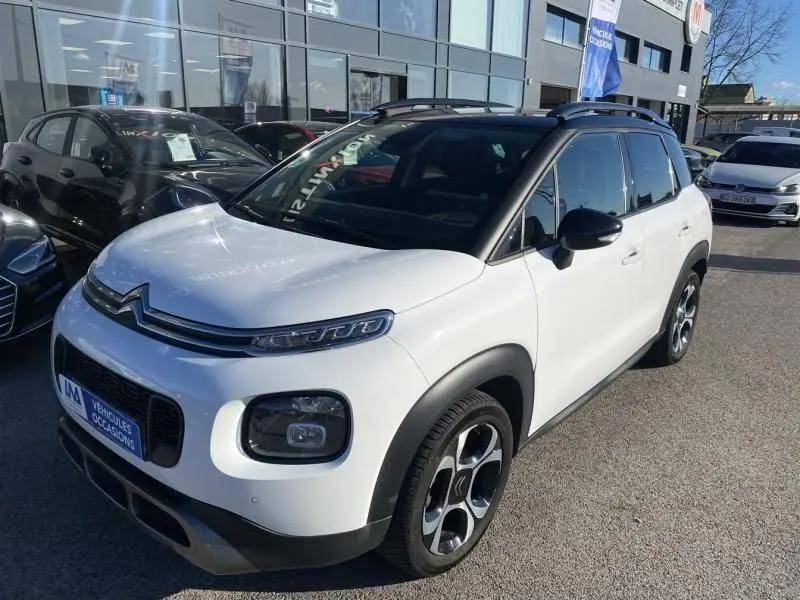 Citroën C3 Aircross blanc vue 3/4 avant droit, toit noir contrasté et jantes distinctives, stationné en extérieur.