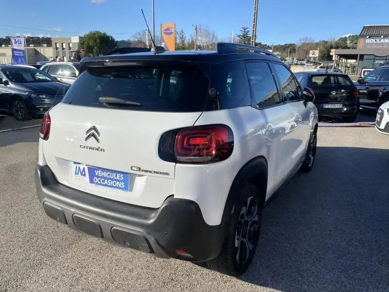 Vue 3/4 arrière droite d'un Citroën C3 Aircross blanc 2019 avec toit noir et feux arrière distinctifs.