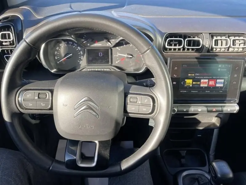 Vue rapprochée du volant et tableau de bord du Citroën C3 Aircross blanc 2019, avec écran tactile et commandes au volant.