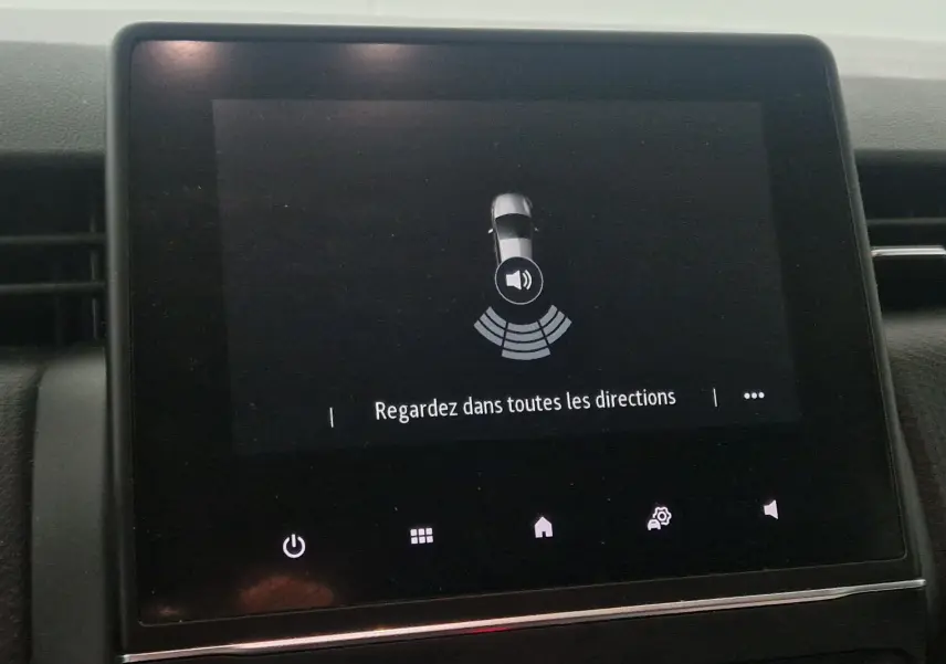 Écran tactile de la Renault Clio V gris platine affichant l'alerte de détection d'obstacles avec message "Regardez dans toutes les directions"