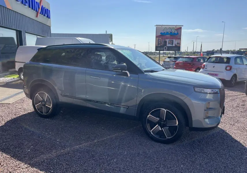 SUV JAECOO J7 gris olive vu de profil côté gauche, avec jantes modernes et vitres arrière surteintées.