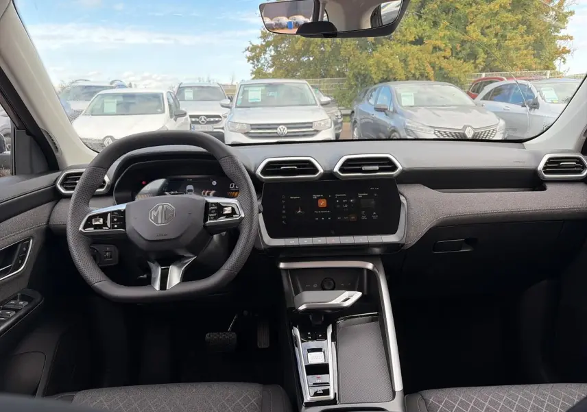 Vue intérieure avant du MG ZS 1.5 hybrid 197 avec tableau de bord moderne et volant multifonction noir.