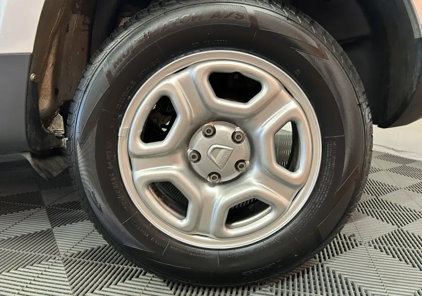 Gros plan sur la roue avant gauche grise du Dacia Duster 2017 avec jante acier et logo central visible.